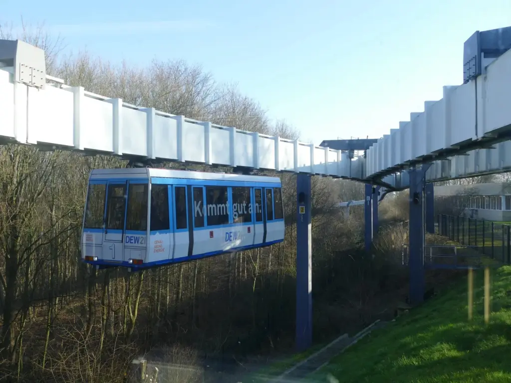 H-Bahn der TU Dortmund in Hombruch schwebt &uuml;ber einem gr&uuml;nen Hang.