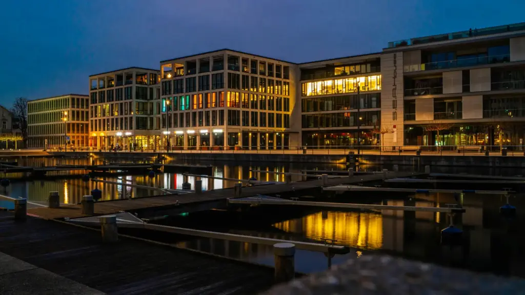 Beleuchtete B&uuml;rogeb&auml;ude am Hafen des Phoenixsees in Dortmund am Abend.