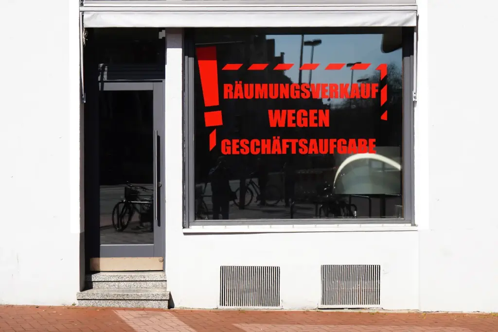 Schaufenster mit roter Aufschrift R&auml;umungsverkauf wegen Gesch&auml;ftsaufgabe.