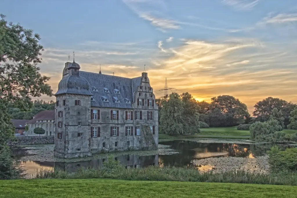 Wasserschloss Bodelschwingh in Dortmund mit Eckt&uuml;rmen im Abendlicht.