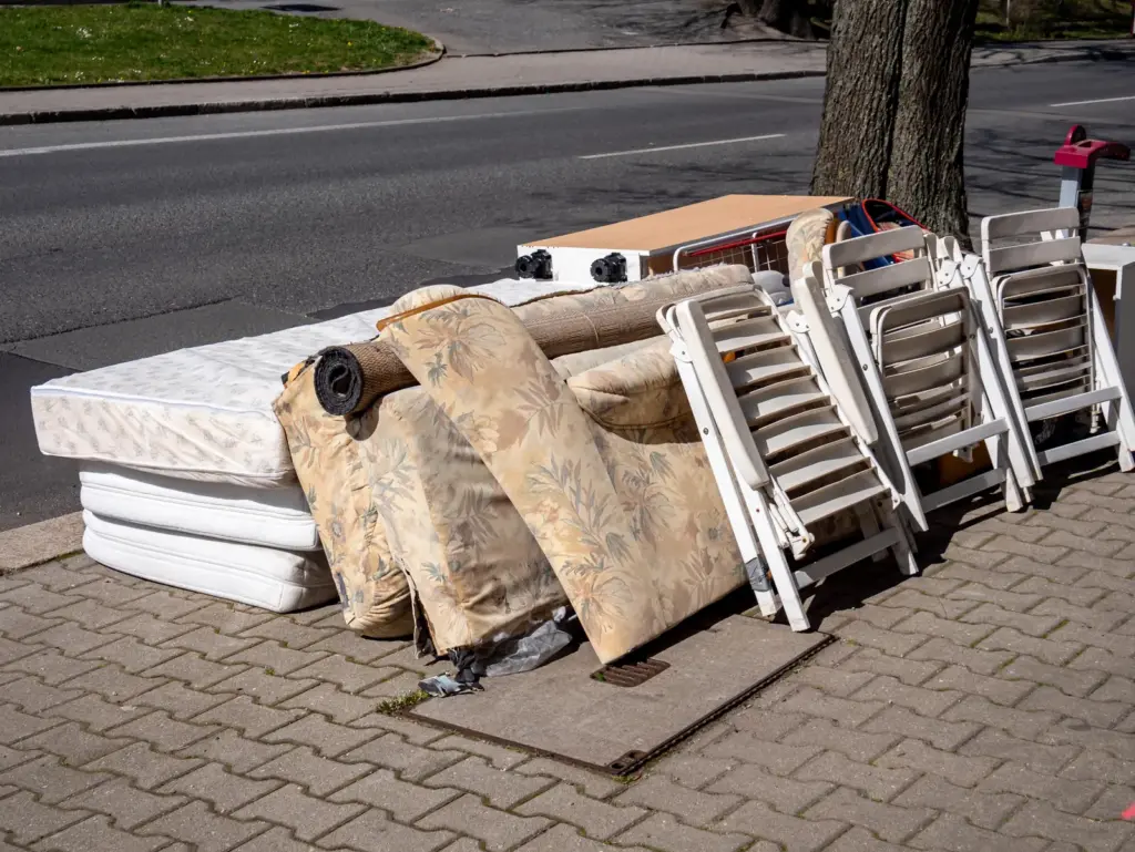 Matratzen, Sessel und Klappst&uuml;hle als Sperrm&uuml;ll am Stra&szlig;enrand.