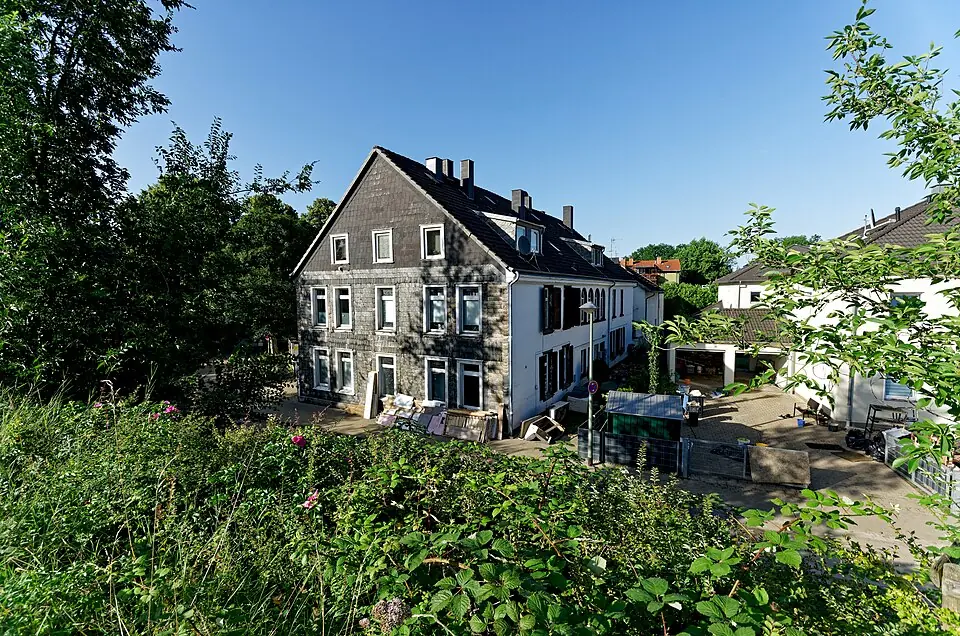 Mehrfamilienhaus mit Schieferfassade und vollgestelltem Hinterhof in Hattingen, Entr&uuml;mpelung vor Ort.