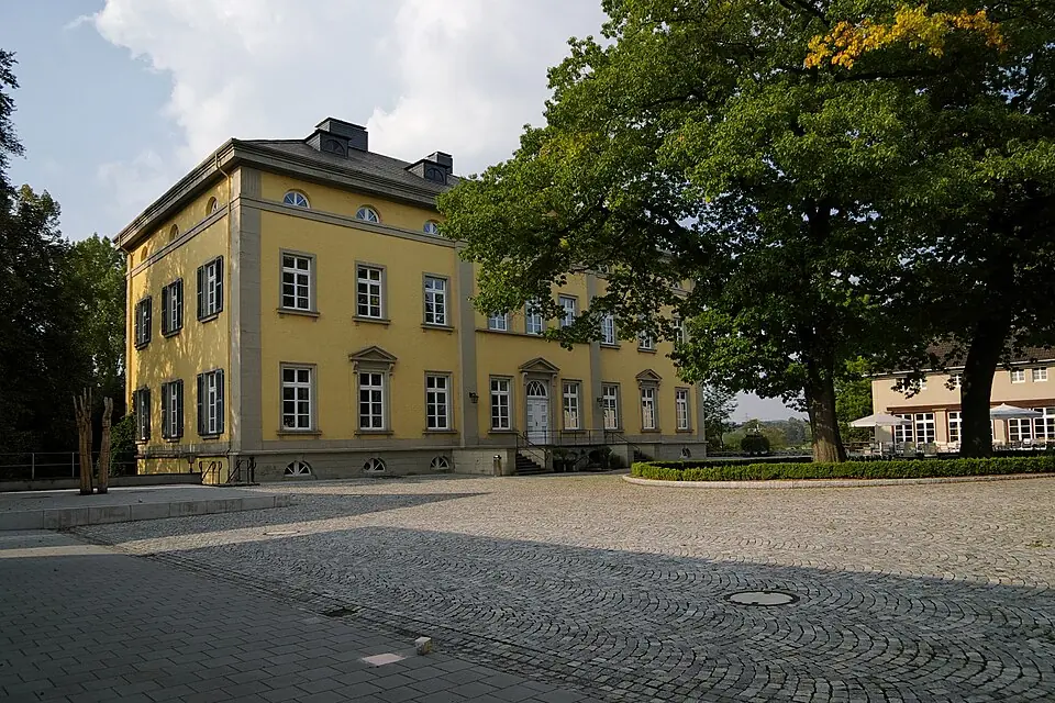 Gelbes klassizistisches Herrenhaus in Schwerte mit Kopfsteinpflaster davor, Haushaltsaufl&ouml;sung in Schwerte.